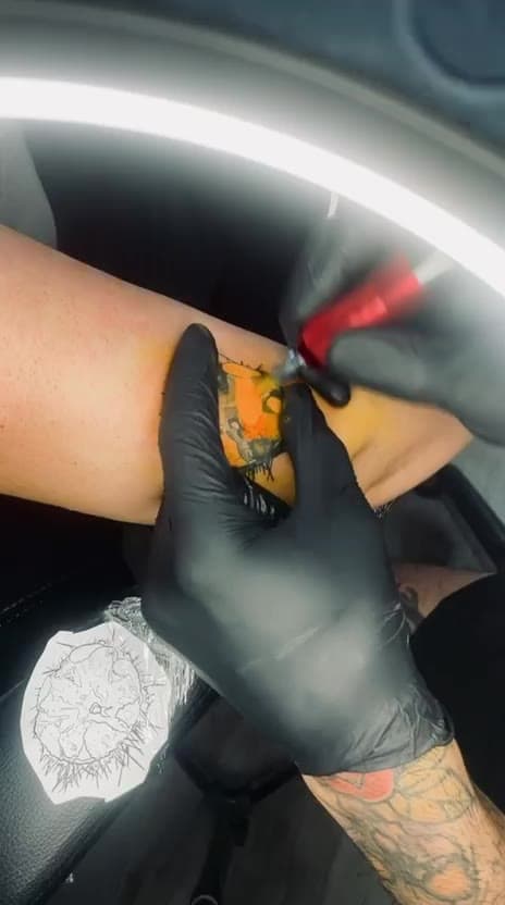 Stefan tattooing an arm piece under the ring light, session in progress — short clip
