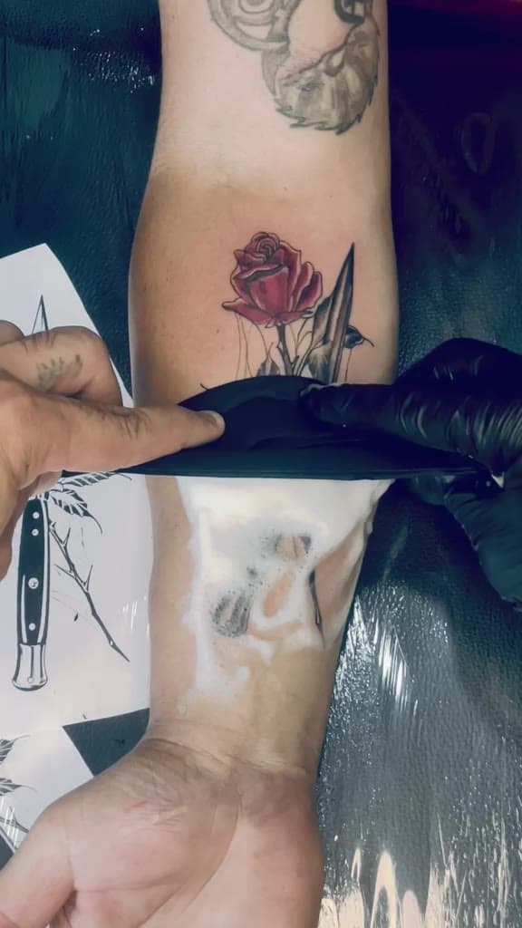 Rose and dagger forearm tattoo, wiped clean after the session — short clip